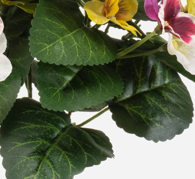 Detailansicht einer künstlichen Stiefmütterchen-Pflanze mit grünen Blättern sowie gelben und lila Blüten.