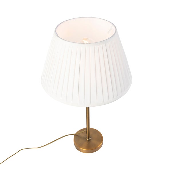 Tischleuchte mit weißem Plissee-Schirm und messingsfarbenem Standfuß aus Metall.