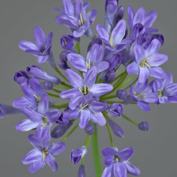 Künstliche Mohnblume mit zwei lila Blüten aus Textilmaterial und grünen Blättern.