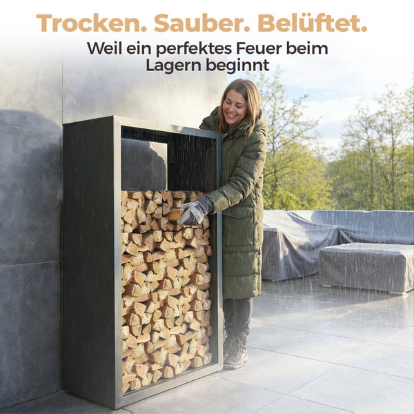Frau legt Brennholz in ein schwarzes Metall-Kaminholzregal auf einer Terrasse im Regen.