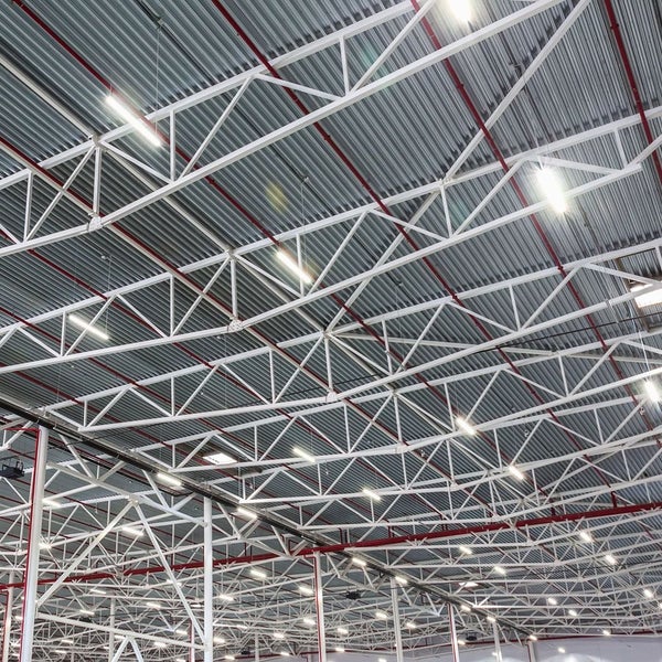 Blick auf eine Hallendecke mit Stahlkonstruktion und Beleuchtung