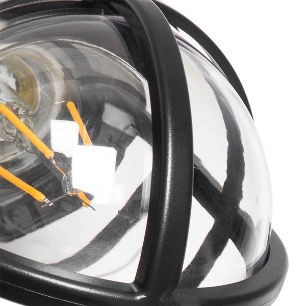 Nahaufnahme einer Außenleuchte mit schwarzem Metallkäfig, klarem Glas und sichtbarem Leuchtmittel.