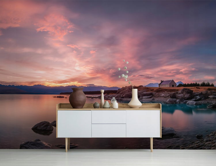 Fototapete mit See- und Sonnenuntergangsmotiv hinter einem Sideboard