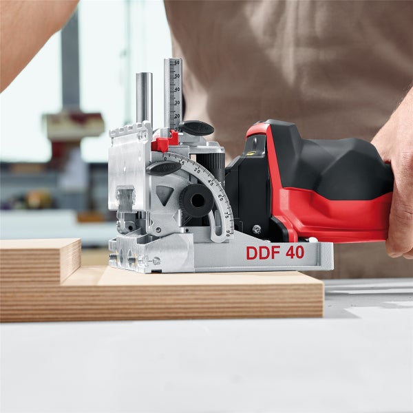 Handwerker nutzt Mafell DDF 40 DuoDübler für präzise Bohrungen in ein Holzwerkstück in der Werkstatt.