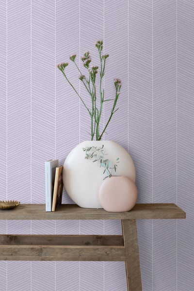 Wohnszene mit gemusterter Tapete, Holztisch und Dekoration