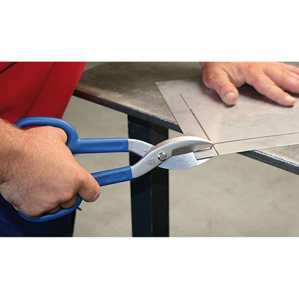 Anwendung einer Blechschere zum Schneiden eines Metallblechs auf einer Werkbank.