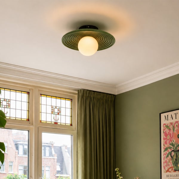 Moderne Deckenleuchte mit tellerförmigem Schirm und runder Glaskugel in einem stilvoll eingerichteten Wohnraum.