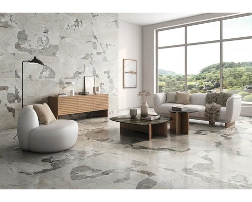 Heller Wohnraum mit Bodenfliesen in Marmoroptik, Sofa, Sessel und Sideboard