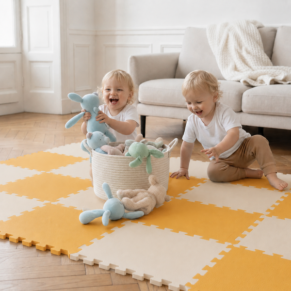 Zwei Kleinkinder spielen in einem hellen Wohnzimmer auf einer Puzzle-Spielmatte mit Stofftieren und einem Aufbewahrungskorb.