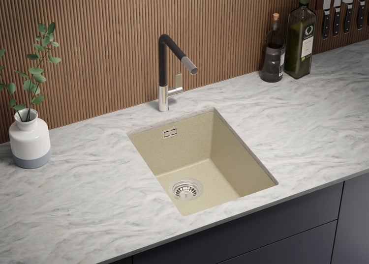 Spüle aus hellem Stein mit Wasserhahn auf einer Küchenarbeitsplatte