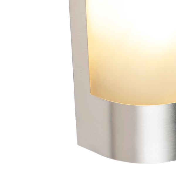 Nahaufnahme einer Wandleuchte aus gebürstetem Edelstahl mit warmweißem Licht.