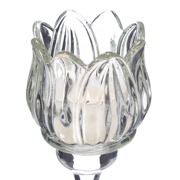 Vier gläserne Teelichthalter in Tulpenform aus geriffeltem Glas in verschiedenen Höhen auf einem hellen Holzmöbel.
