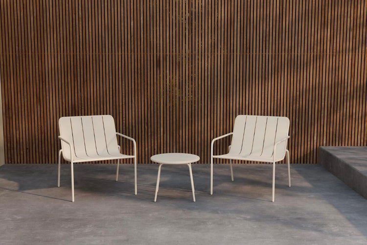 Dreiteiliges Gartenmöbel-Set mit zwei Sesseln im Lamellendesign und einem runden Beistelltisch vor einer Wand aus Holzlatten.