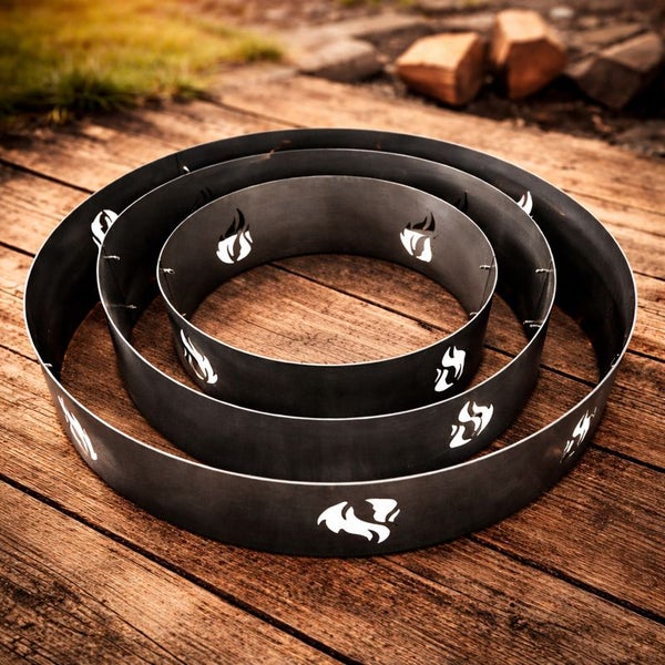 Drei kreisförmige Feuerstellen-Einfassungen aus Metall mit Aussparungen in Flammenform.