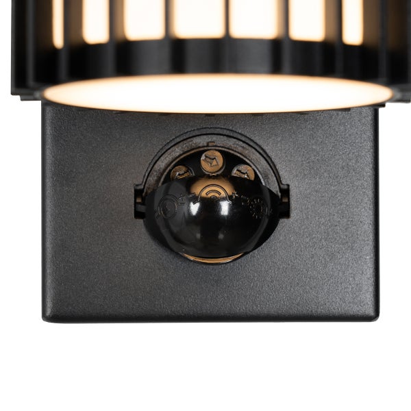 Nahaufnahme eines Bewegungsmelders an einer schwarzen Außenleuchte mit Einstellreglern für Zeit und Helligkeit.