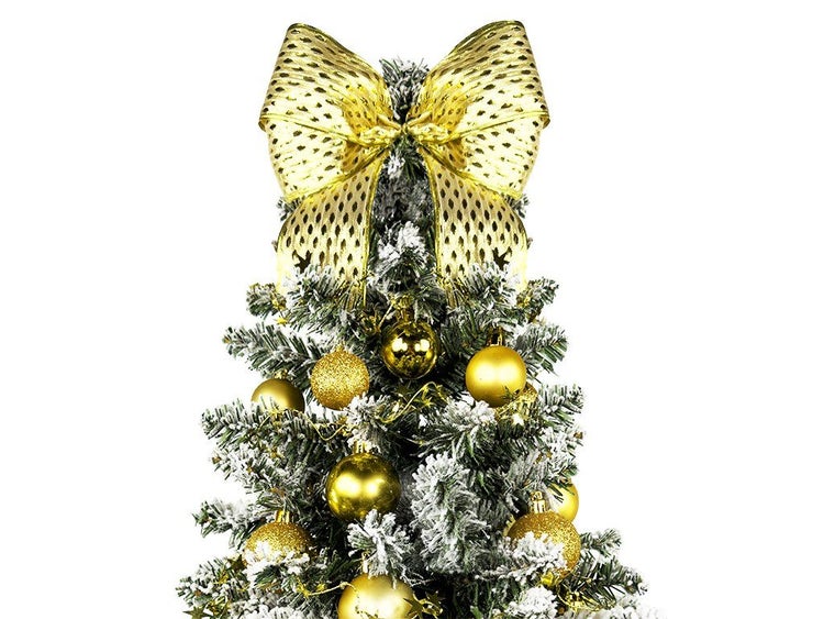 Weihnachtsbaumspitze in Form einer großen Schleife auf einem künstlich beschneiten Weihnachtsbaum mit Kugeln.