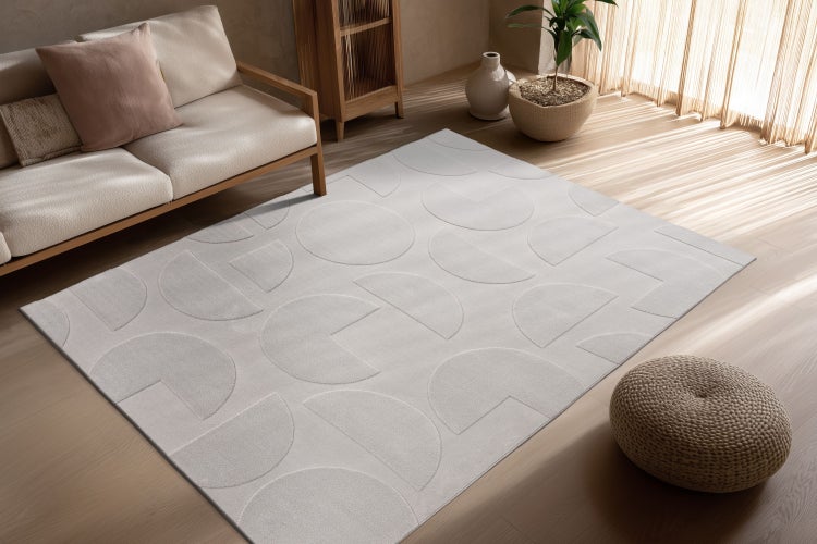 Moderner Wohnzimmerteppich mit geometrischem Kreis Muster in einem hellen Wohnbereich mit Holzmöbeln und Sofa