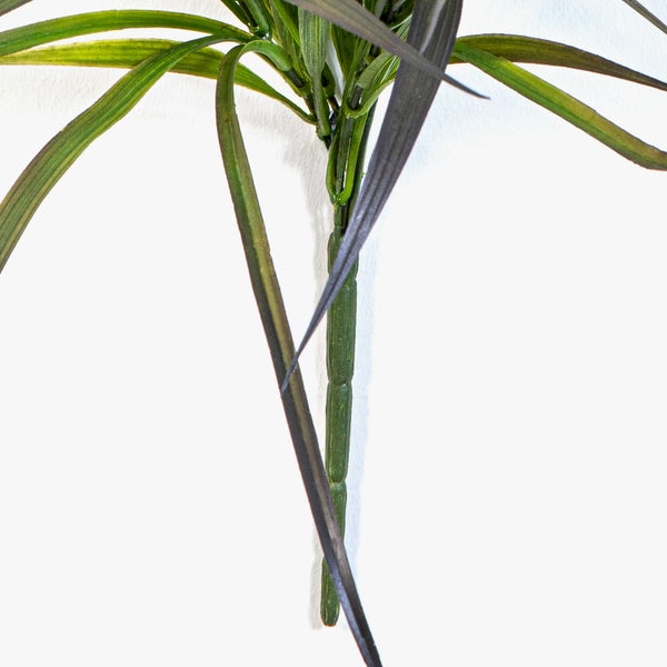 Künstlicher Pflanzenzweig mit langen, schmalen Blättern aus Kunststoff.