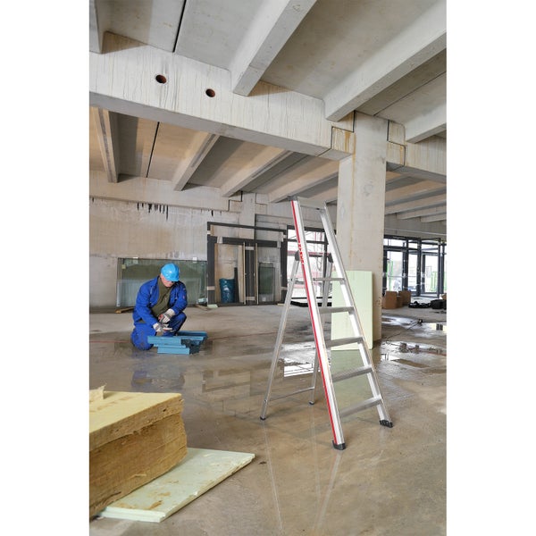 Innenaufnahme einer Baustelle mit einer Aluminiumleiter und einem Arbeiter