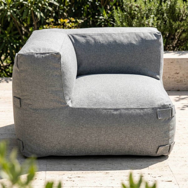 Eckmodul für Gartenlounge mit grauem Textilbezug auf einer Terrasse im Garten.