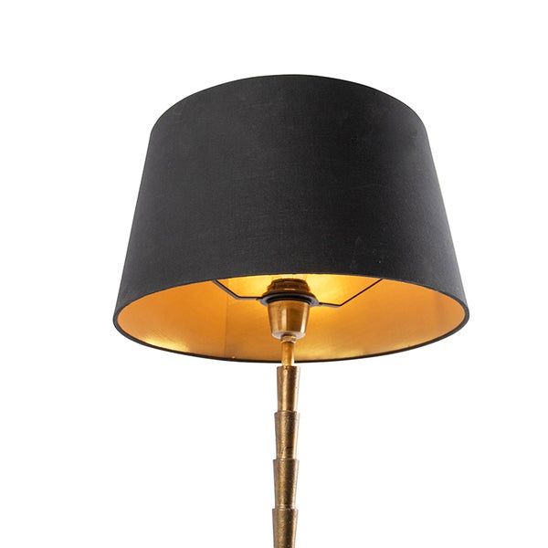 Stehlampe mit schwarzem Lampenschirm und goldfarbenem Lampenfuß
