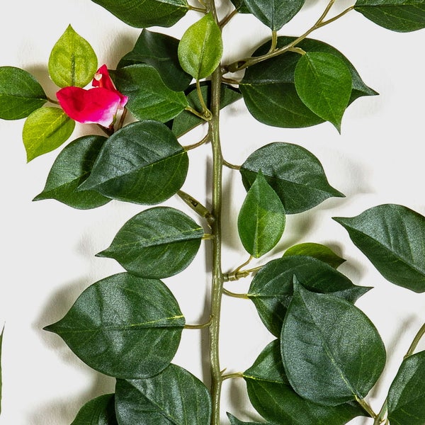 Künstliche Blume mit weißen Blütenblättern, grünem Blütenstand und grünen Blättern am Stiel.