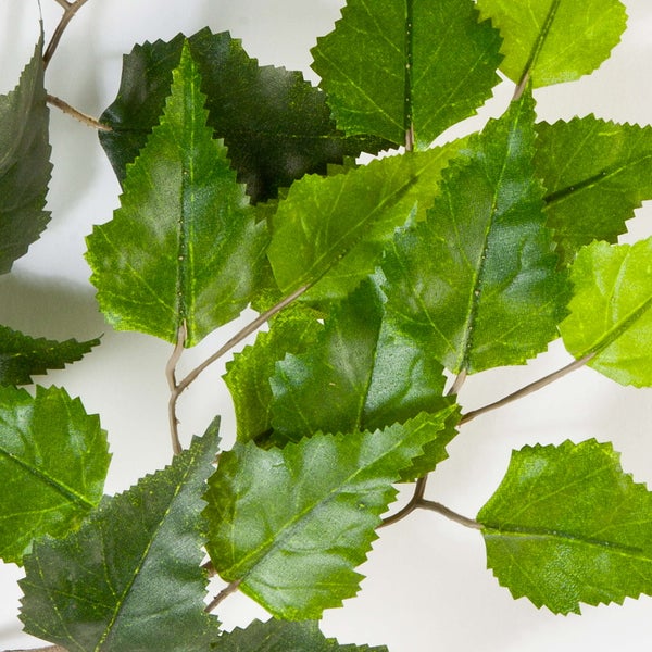 Künstlicher Birkenzweig mit grünen Blättern und braunem Stiel.
