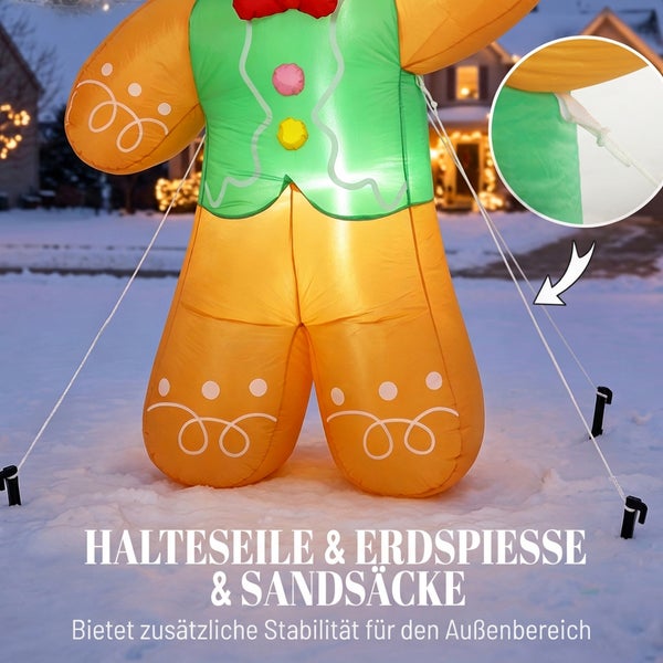 Aufblasbarer Lebkuchenmann für den Außenbereich mit Halteseilen, Erdspießen und Sandsäcken für zusätzliche Stabilität im Schnee.