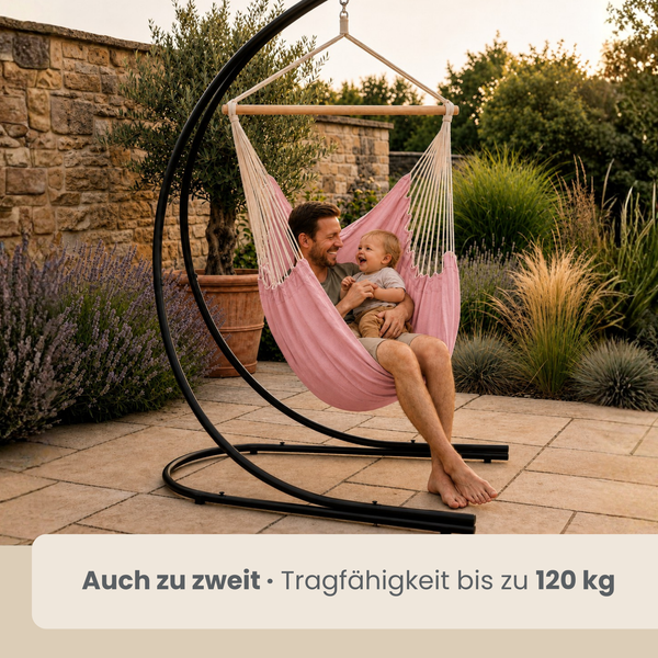 Vater und Kind im Hängesessel mit schwarzem Metallgestell auf einer Gartenterrasse, Tragfähigkeit bis 120 Kilogramm.