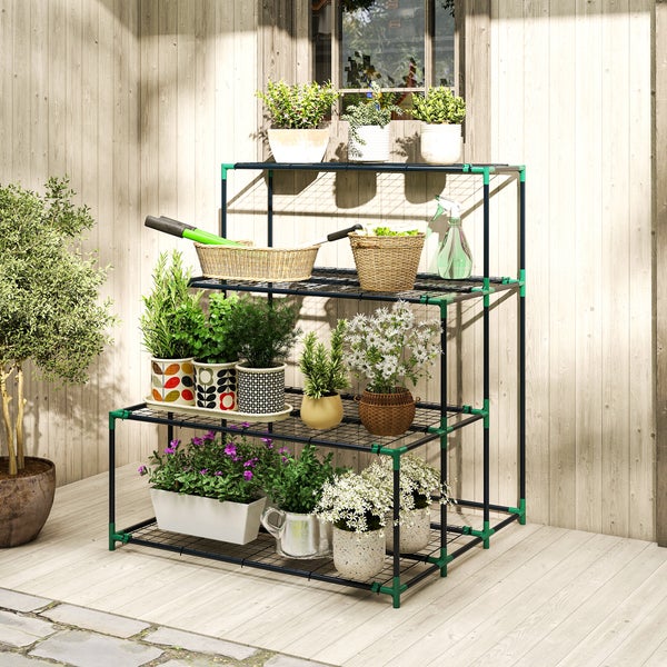 Dreistufiges Gartenregal aus Metall mit verschiedenen Topfpflanzen, Kräutern und Gartenwerkzeug auf einer Holzterrasse.