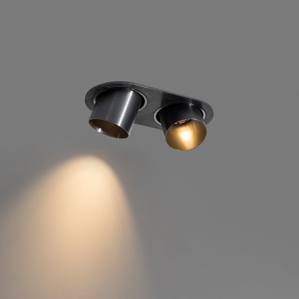 Deckenleuchte mit zwei Spots aus Metall, ein Spot eingeschaltet mit warmweißem Lichtkegel.
