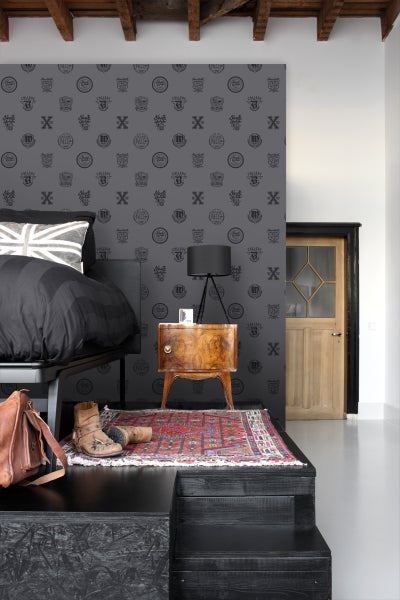 Schlafzimmer mit Bett, Nachttisch, Teppich und gemusterter Tapete