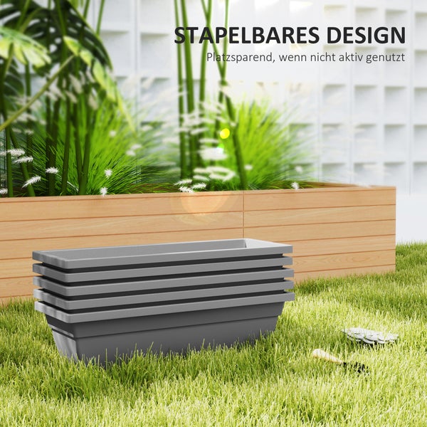 Fünf graue stapelbare Blumenkästen aus Kunststoff auf einem Rasen vor einem hölzernen Hochbeet.