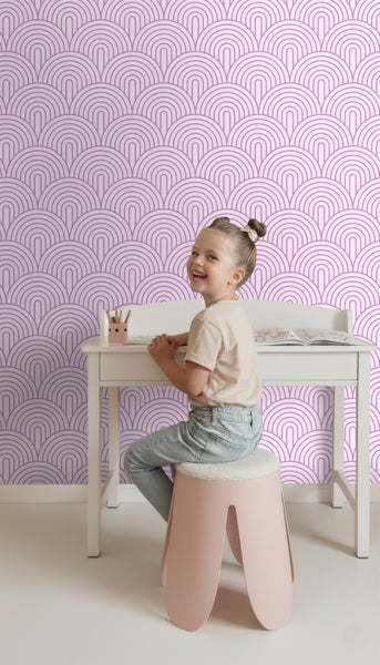 Mädchen am Schreibtisch vor einer Wand mit Halbkreis-Tapete