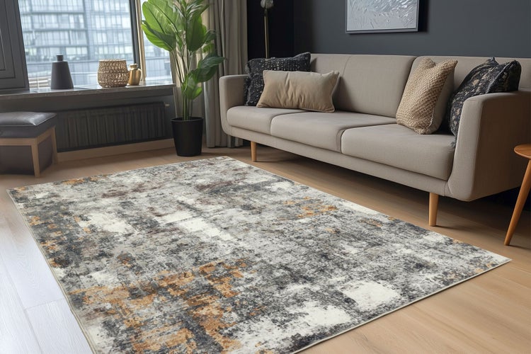 Moderner Wohnzimmerteppich mit abstraktem Muster in einem hellen Wohnraum mit Sofa und Zimmerpflanze.
