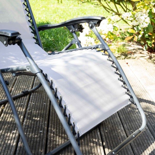 Garten-Relaxsessel mit Textilbespannung und Stahlgestell auf einer Holzterrasse.