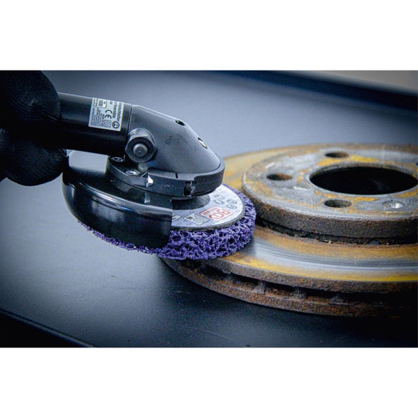 Schleifscheibe an einem Winkelschleifer beim Entfernen von Rost von einer Bremsscheibe