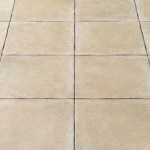 Quadratische Terrassenplatten aus Naturstein mit strukturierter Oberfläche in einheitlichem Verlegemuster als Bodenbelag für den Außenbereich