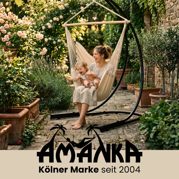 Frau und Kind in einem beigen Hängesessel mit schwarzem Gestell im Garten mit Pflanzen und Steinweg. Amanka Logo.