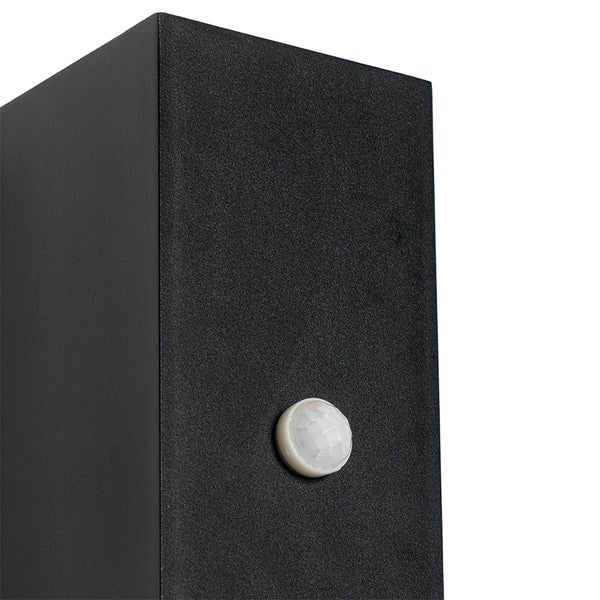 Bewegungssensor an einer schwarzen Außenwandleuchte aus Metall.