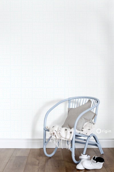 Szene mit einem Stuhl, einem Kissen, einer Decke und Kinderschuhen vor einer strukturierten Tapete