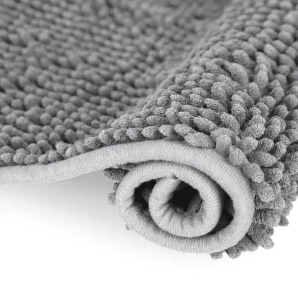 Nahaufnahme einer grauen zusammengerollten Chenille-Badematte mit weicher Textur.