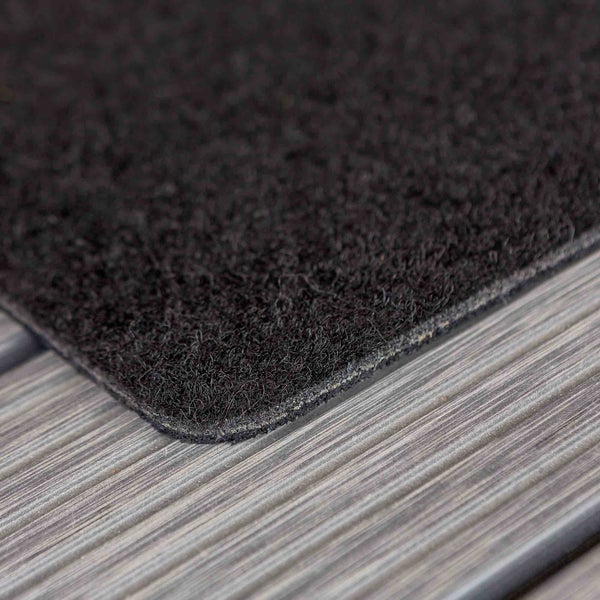 Schwarzer Teppich auf Holzuntergrund