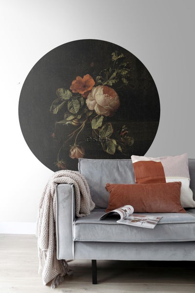 Wohnzimmer mit einer Fototapete mit Blumenmotiv über einem grauen Sofa.