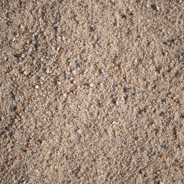 Nahaufnahme von feinem Sand mit unterschiedlichen Korngrößen und Mineralien.