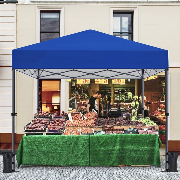 Blaues Faltzelt mit Obst- und Gemüsestand vor einem Gebäude