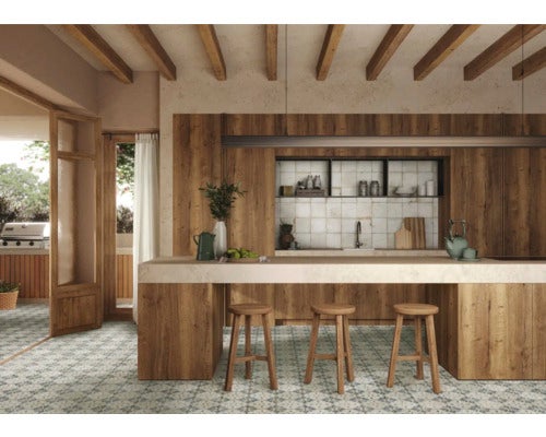 Helle Küche mit Holzelementen, Fliesenboden und Tresen mit Barhockern.