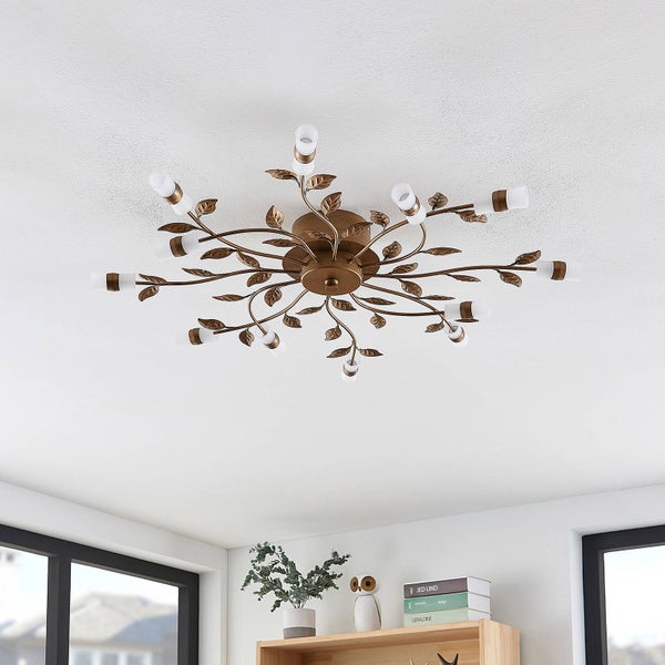 Helle Raumszenerie mit einer Deckenleuchte im floralen Design mit bronzefarbenen Zweigen und weißen Glasschirmen über einem Holzregal.