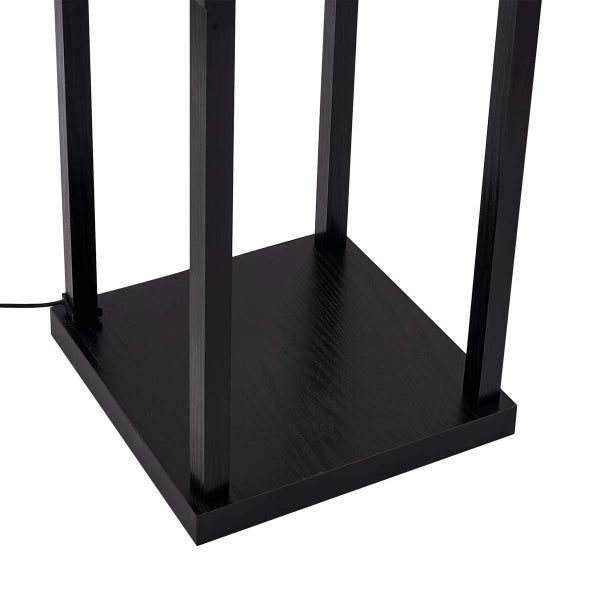 Detailaufnahme eines schwarzen Holzfußes einer Stehlampe.