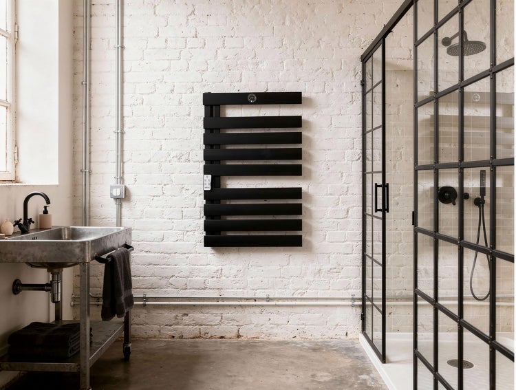 Badezimmer mit Waschbecken, Handtuchwärmer und Duschkabine vor einer weißen Ziegelwand